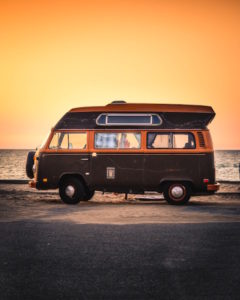 Campervan parked in front of a beach sunset