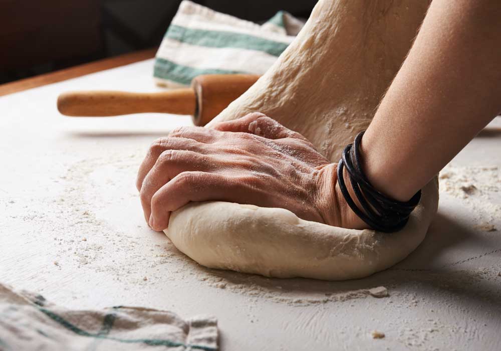 Bakery insurance - Shows a person kneading dough
