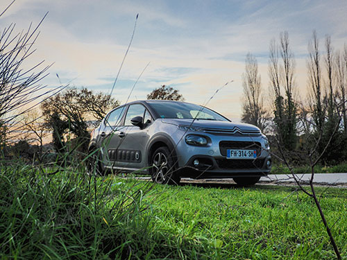Blue Citroen C3 on a road next to grass area