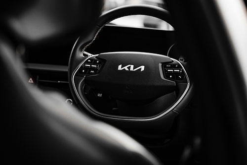 A woman sitting in a car with a steering wheel