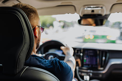 Man in glasses driving a car