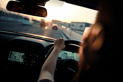 A woman sitting in a car with a steering wheel