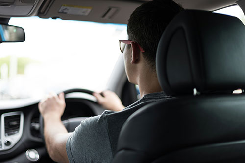 A woman sitting in a car with a steering wheel