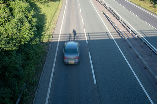 Car speeding past under a bridge