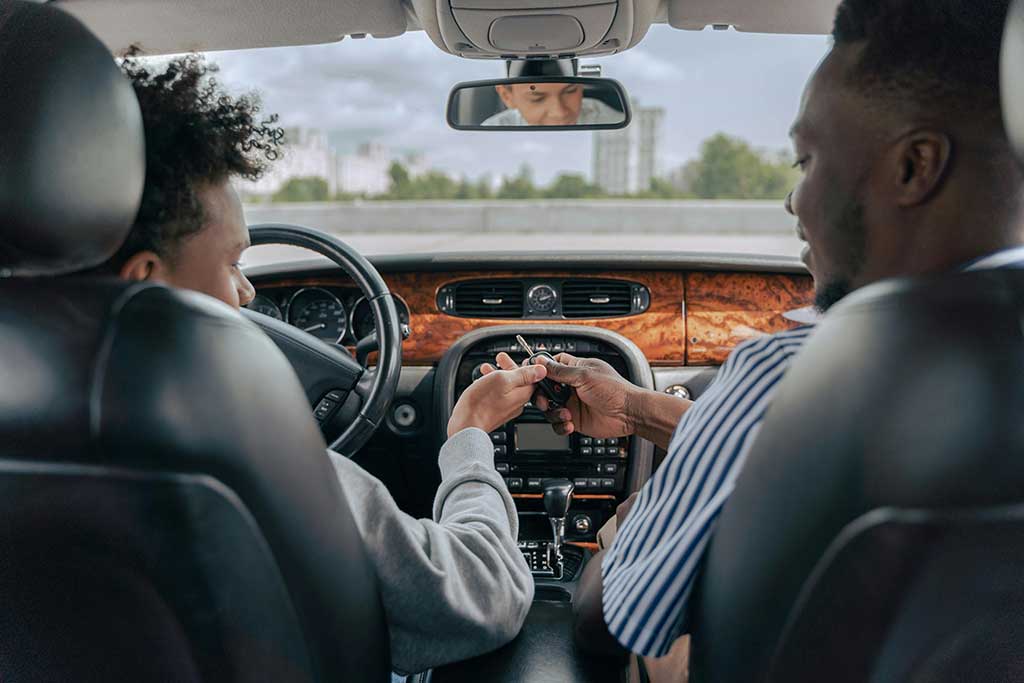 Man passing young man car key