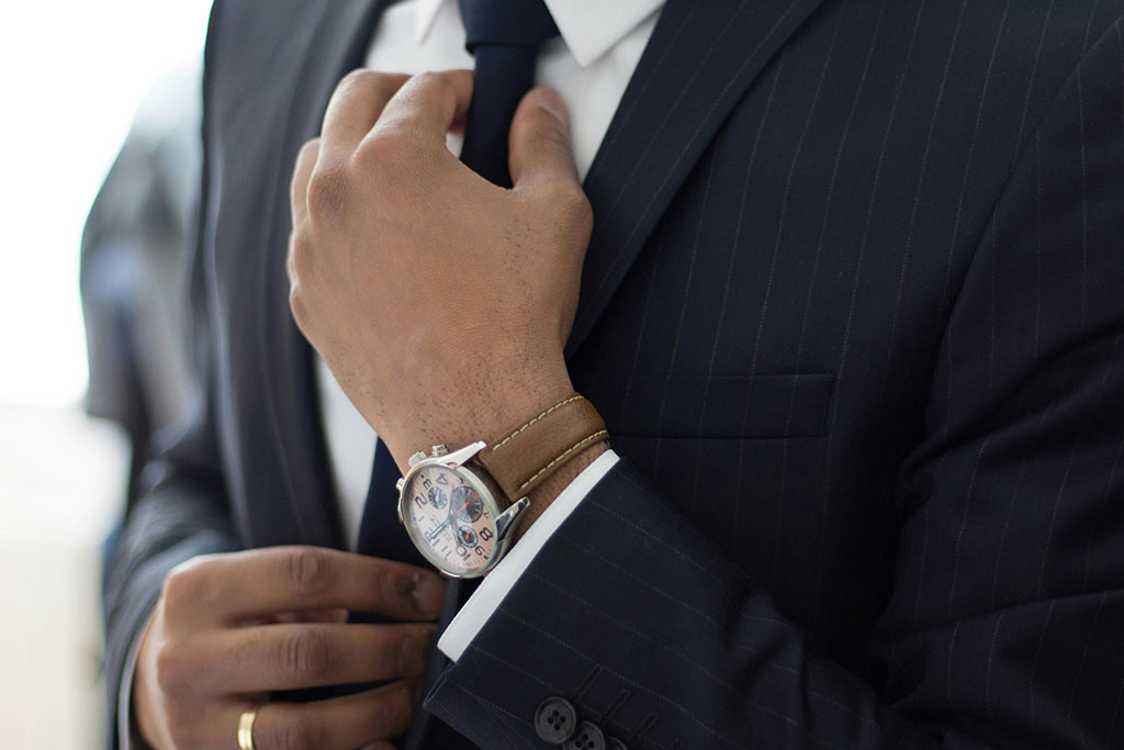 Man in a suite doing up his tie
