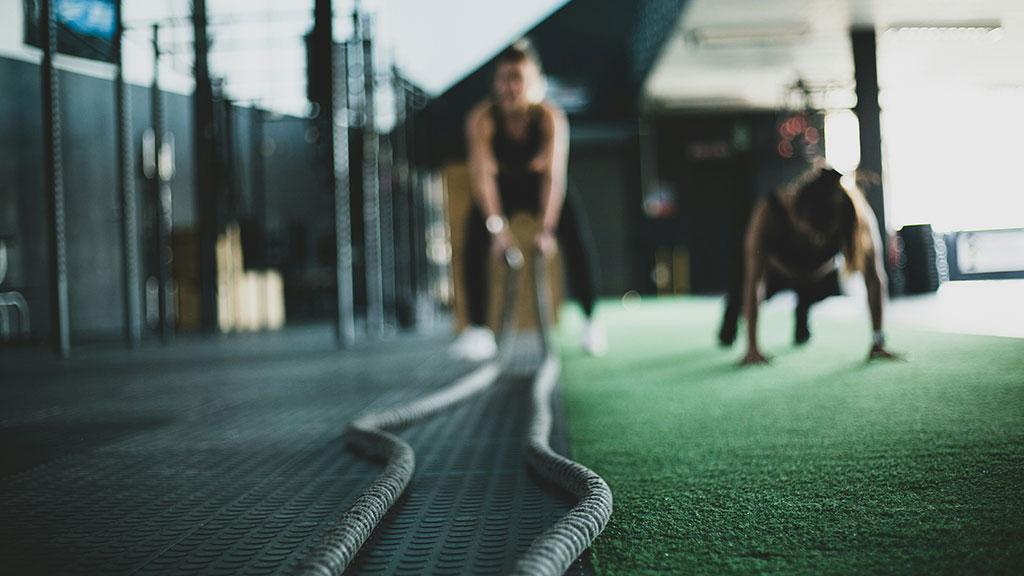 Woman in the gym on battle ropes