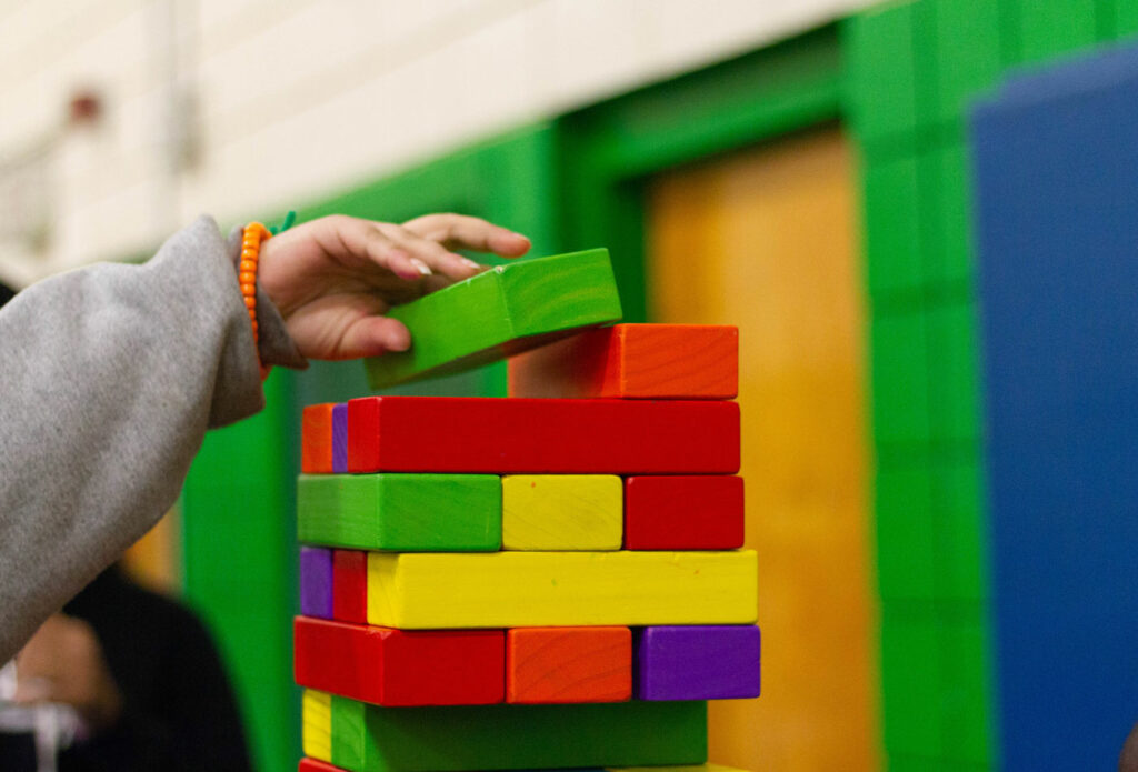 shows an image of a child putting coloured blocks together - how to set up childrens soft play