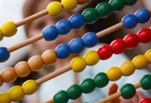 Shows a child looking at a colourful abacus