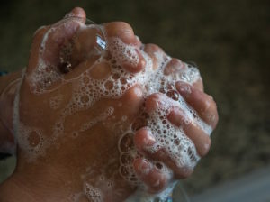 Shows a person washing their hands