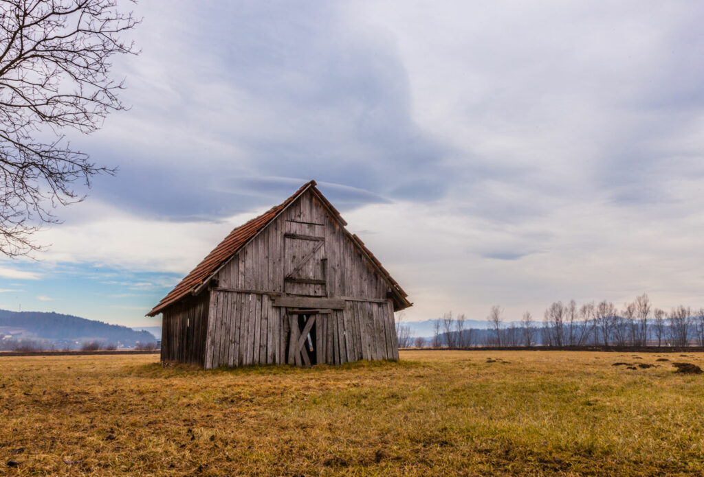 shows an image of a barn in the middle of a field