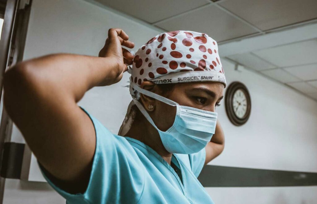Shows a medical professional getting ready for surgery