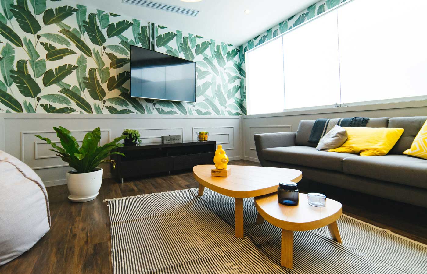 Trendy living area with a sofa and tropical-print wallpaper