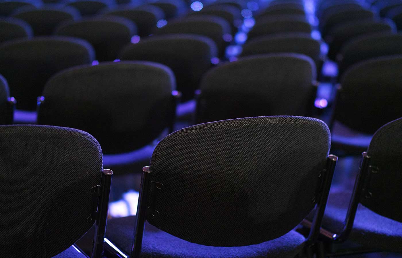 corporate event planning guide - Shows rows of empty chairs at a conference