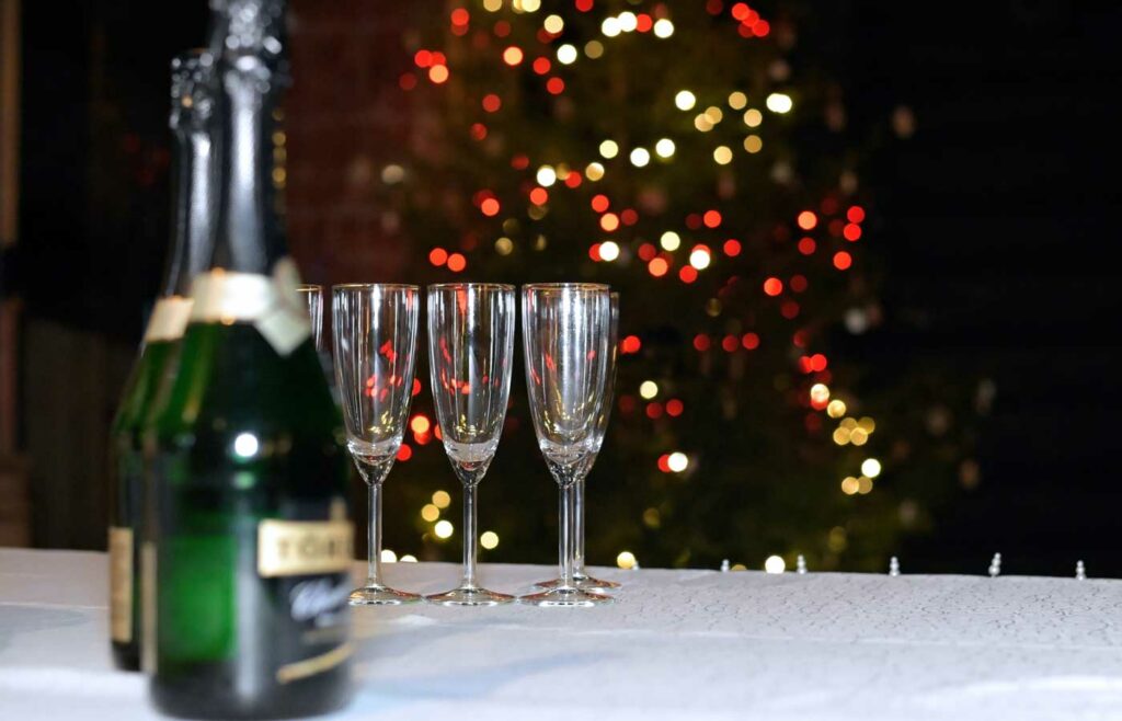 shows an image of a bottle of champagne on a table - christmas event planning insurance