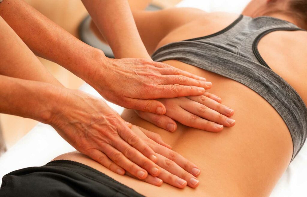 shows an image of a physiotherapist massaging someones back