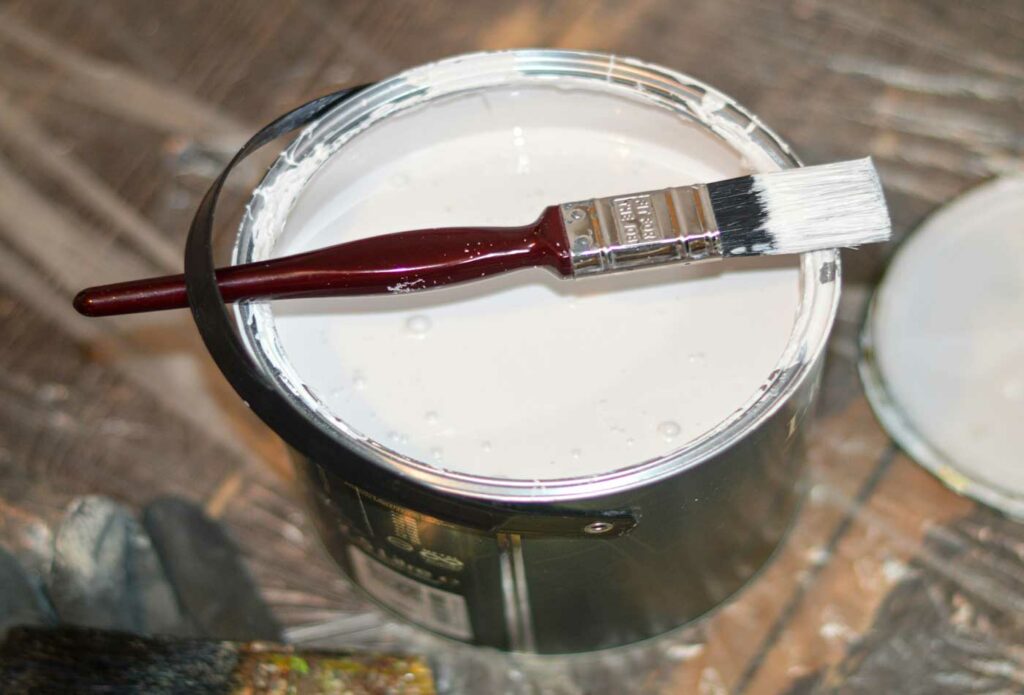 shows a white pot of paint and a paint brush - contractor insurance
