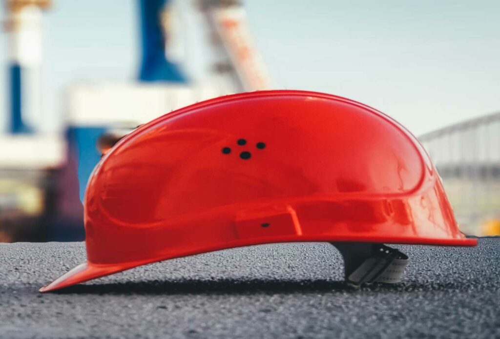 shows a red hard shell hat on the ground - how to start a construction company