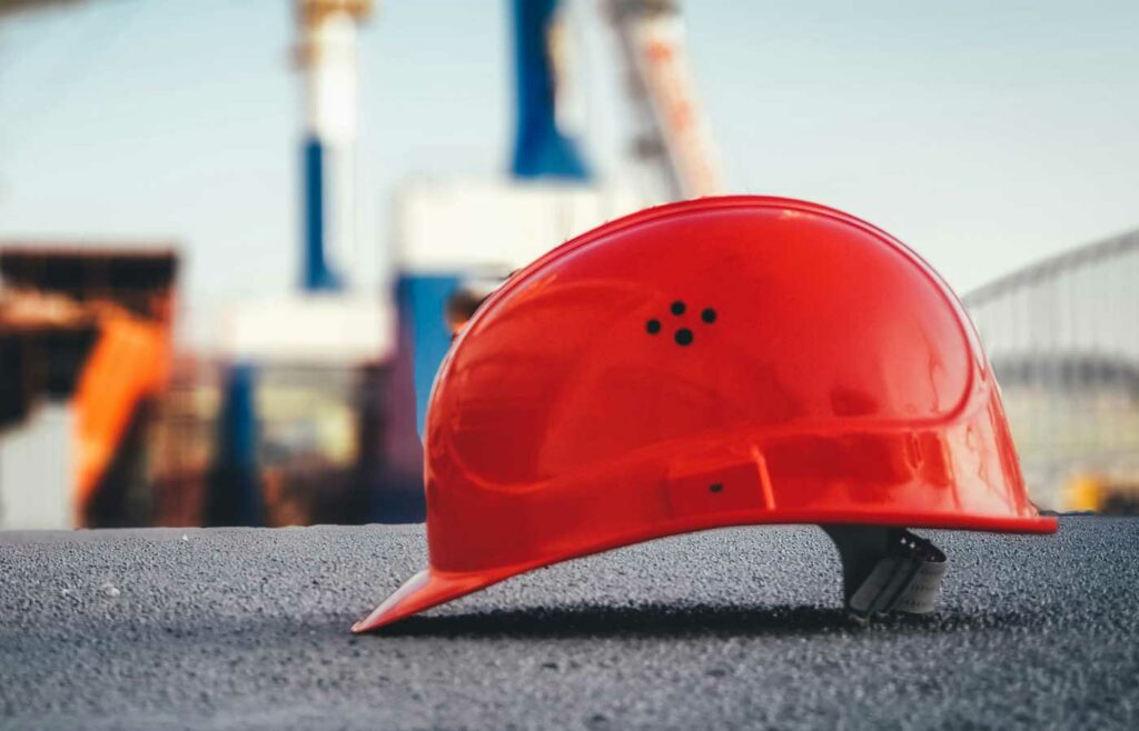 shows a red hard hat on the ground - construction safety guide