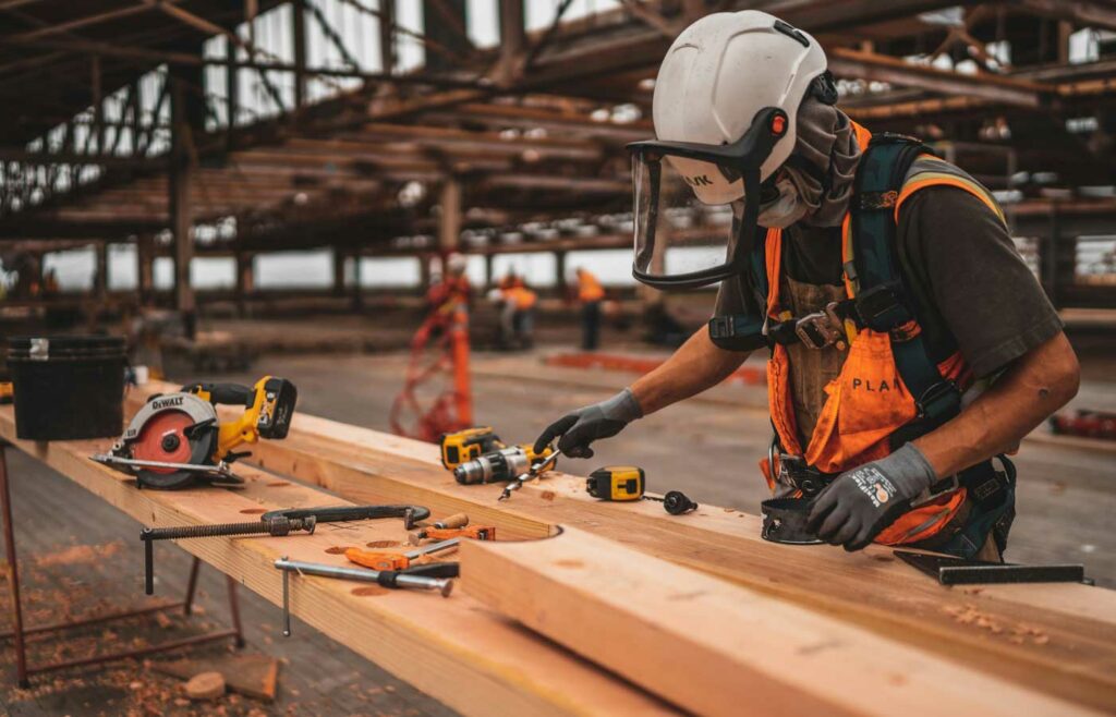 shows a construction worker drilling into wood - construction site safety 