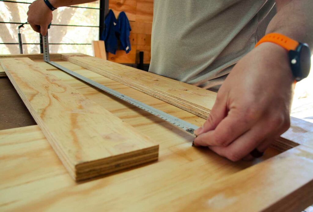 shows a man measuring out wood planks - carpenter public liability insurance