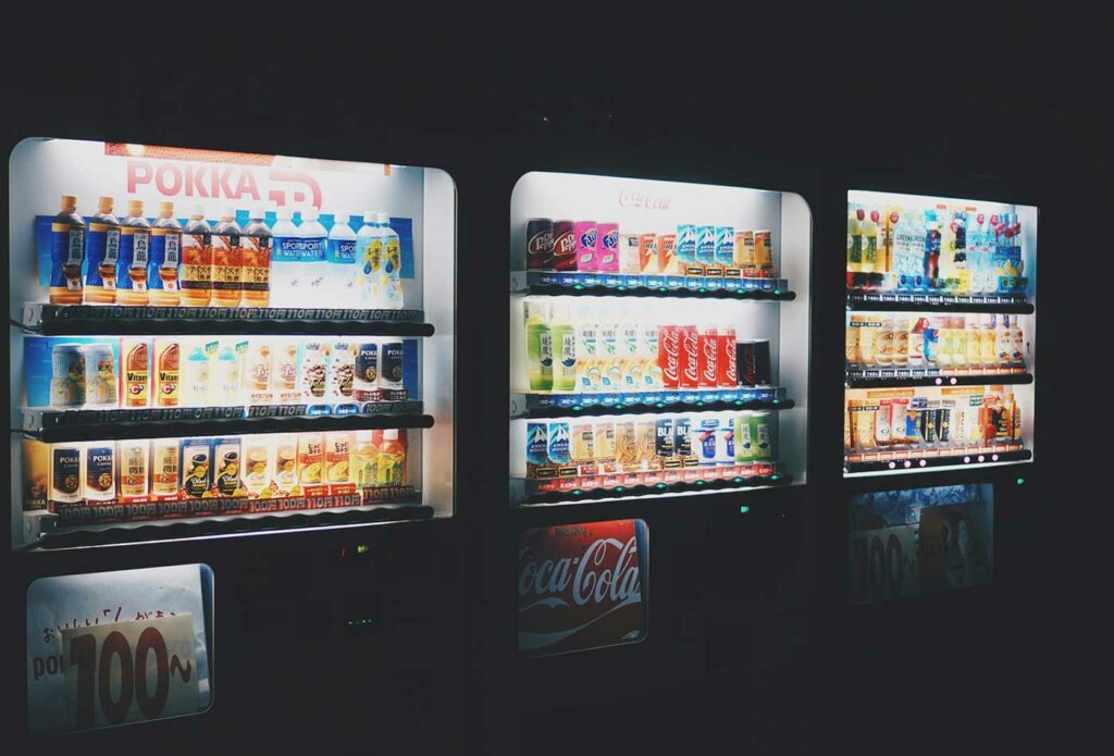 shows a side view of a vending machine at night - starting a vending machine business