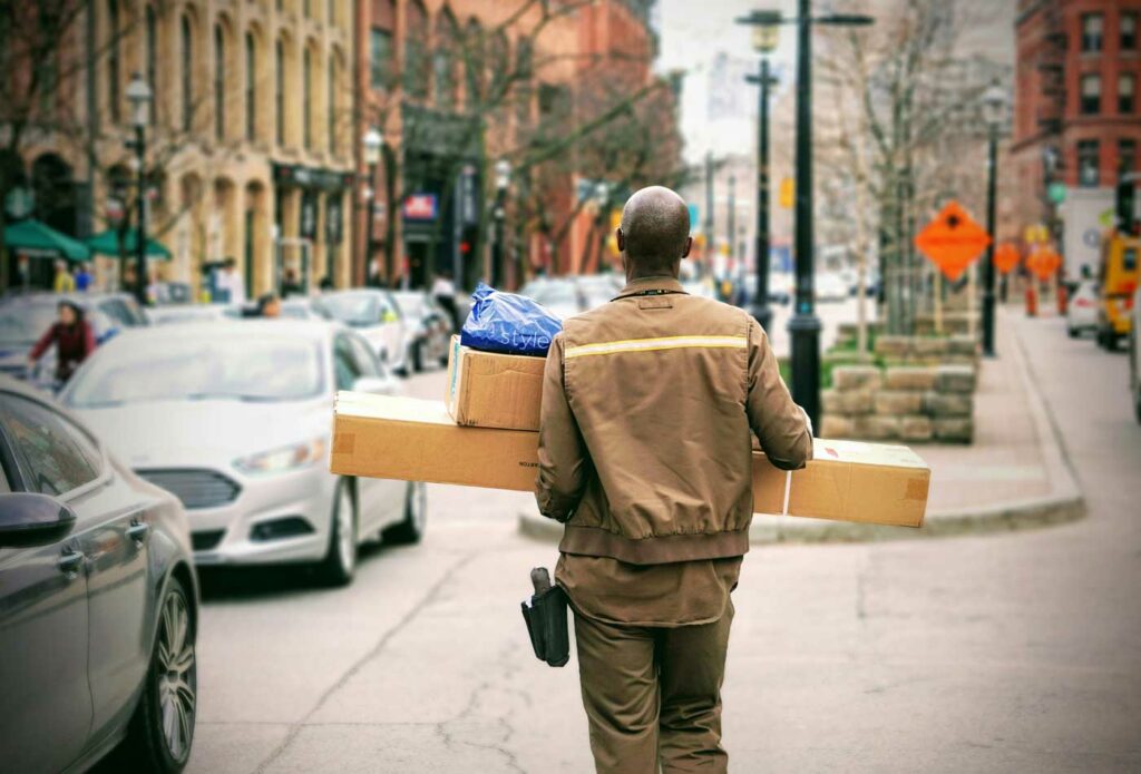 shows a courier carrying boxes