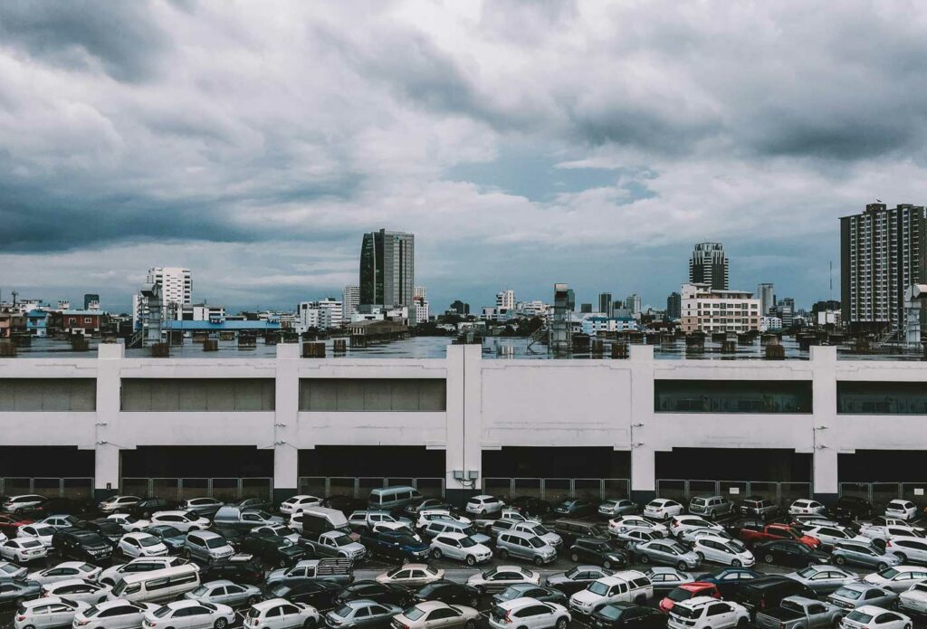 impound vehicle insurance - shows cars in a parking lot in front of skyscraper buildings