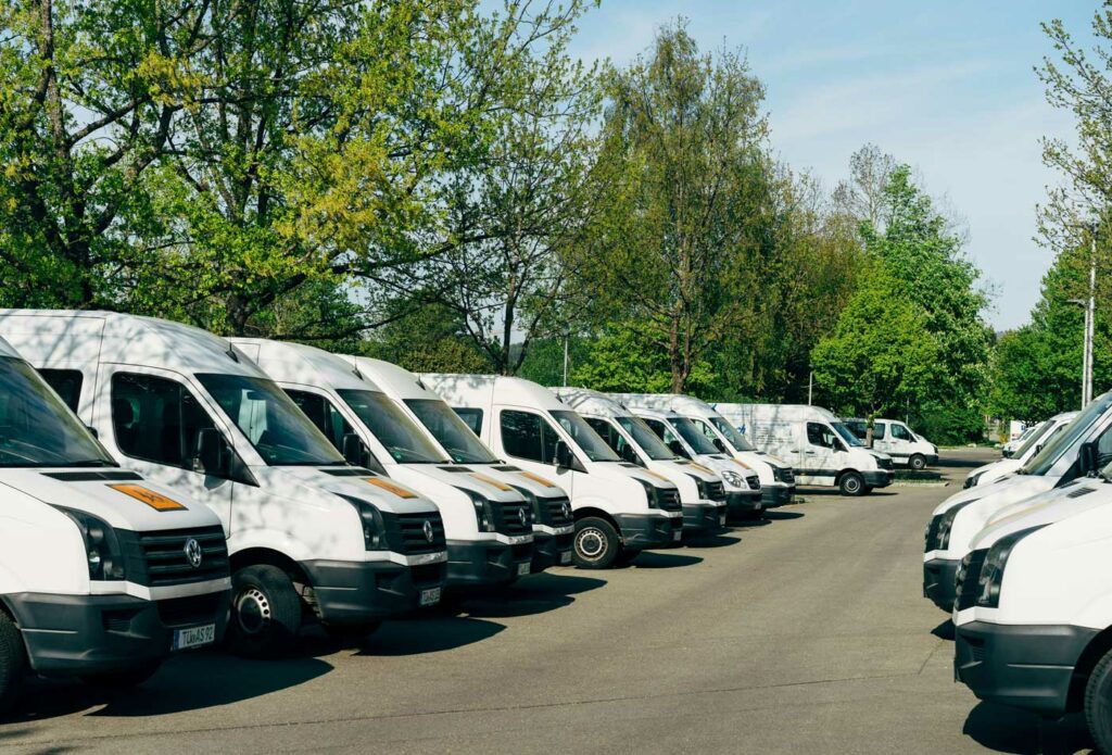 shows white vans lined up next to each other - start a successful automotive business