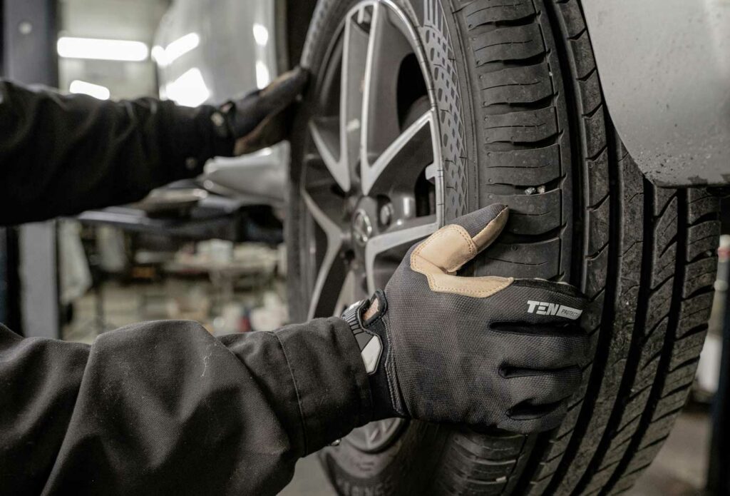 shows a mechanic changing a car tyre