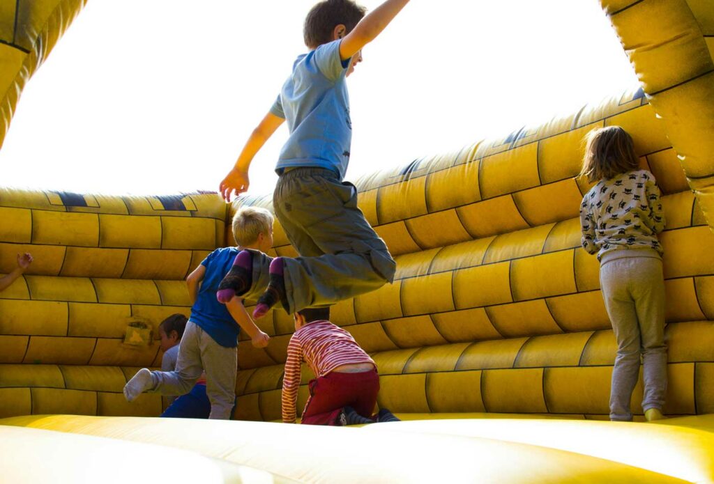 shows kids playing in the bouncy castle 