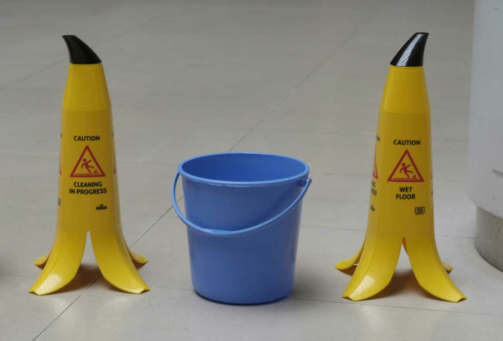 shows two wet floor signs and a bucket - do i need business insurance?