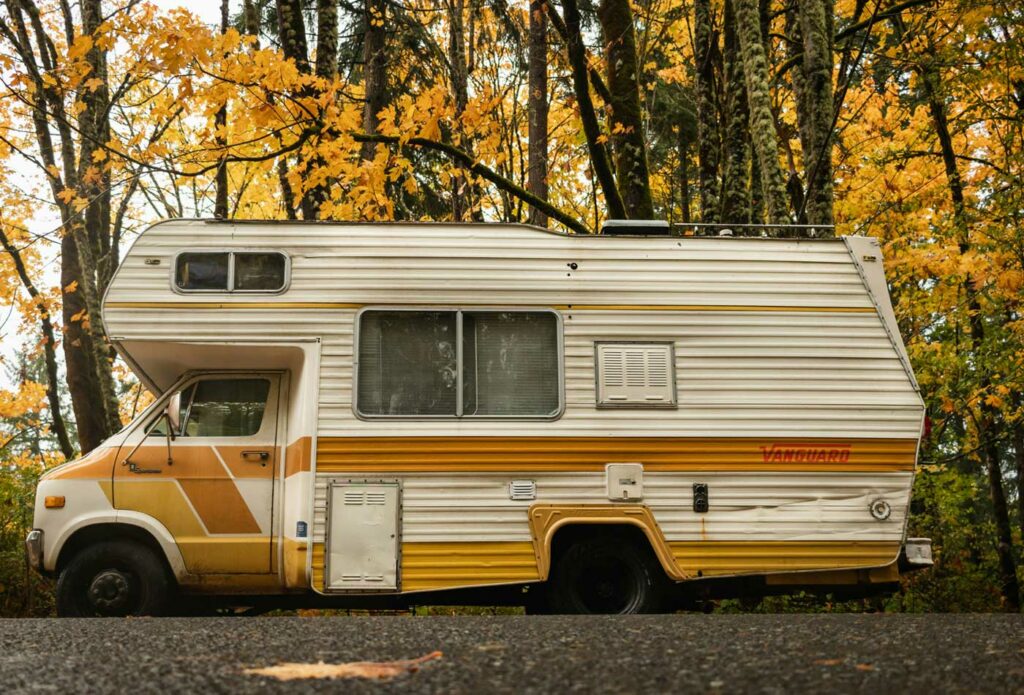 shows a white campervan in the forest