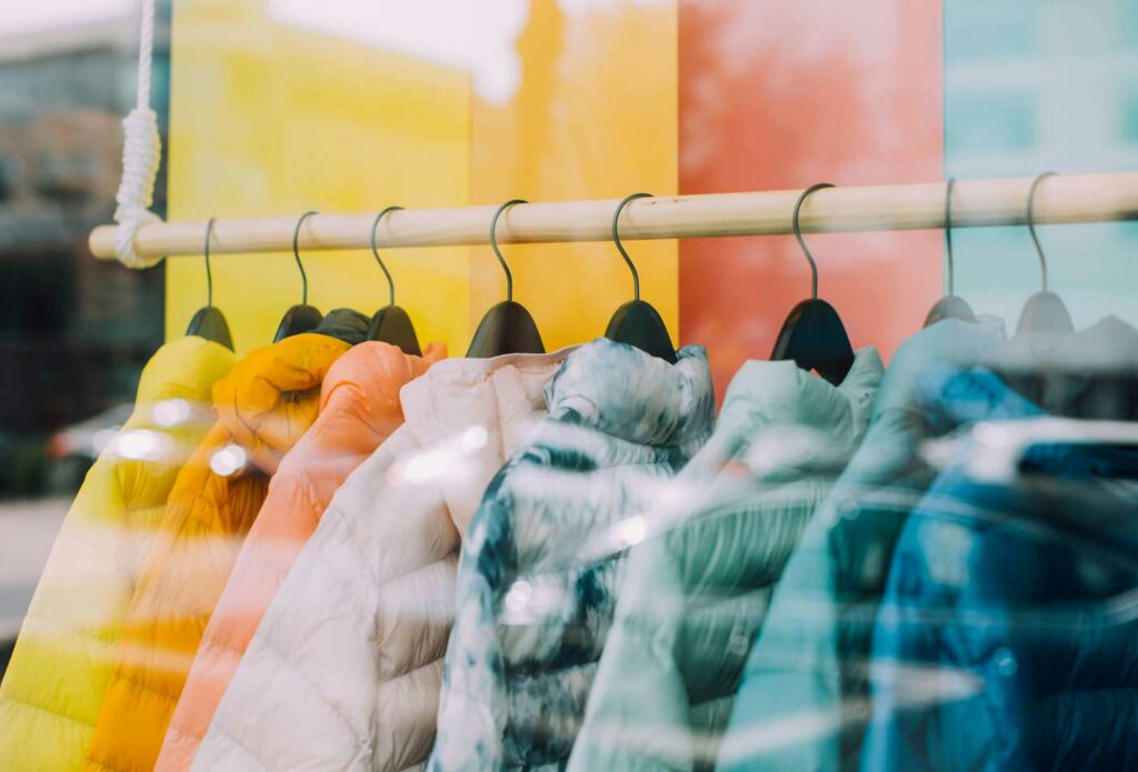 shows a rail of different coloured coats - shop business insurance