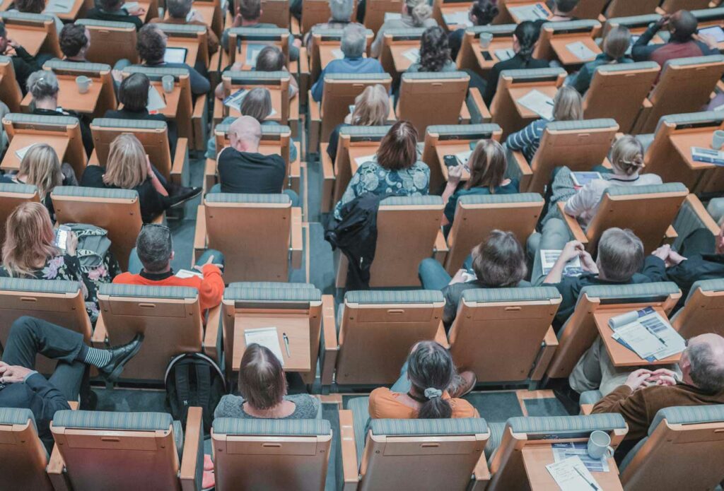 shows people sat in chairs in a conference room - conference event insurance